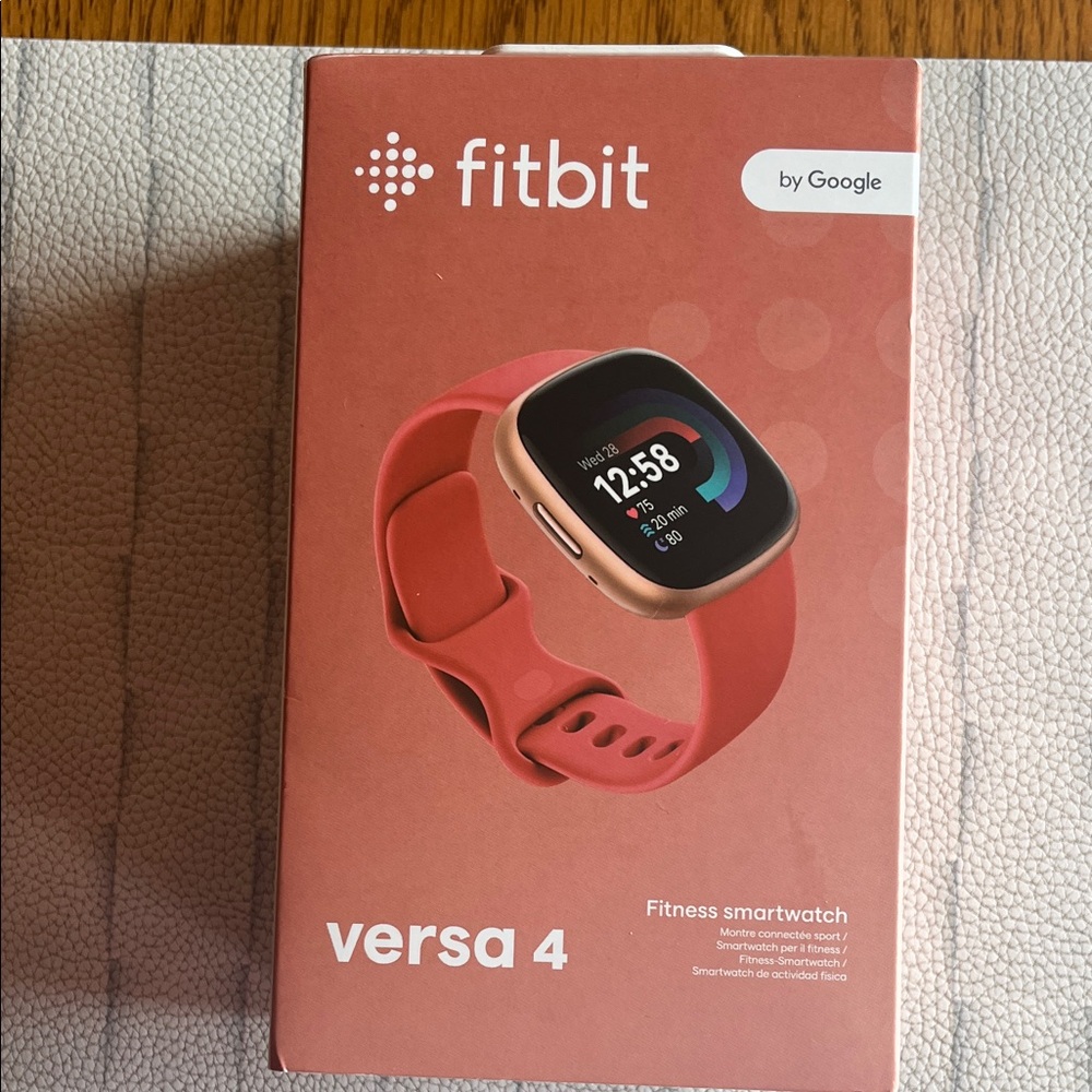 New fitbit Versa 4 Smartwatch - Coral Band with Rose Gold Case never opened